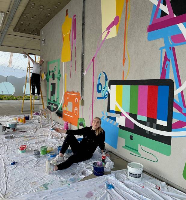 Kirsty and Brittany pause for a photo while painting the mural