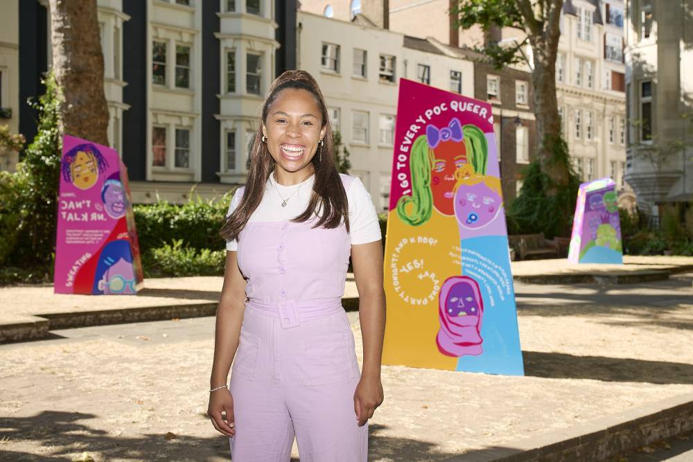 Fiona stands in front of some of her work in a park