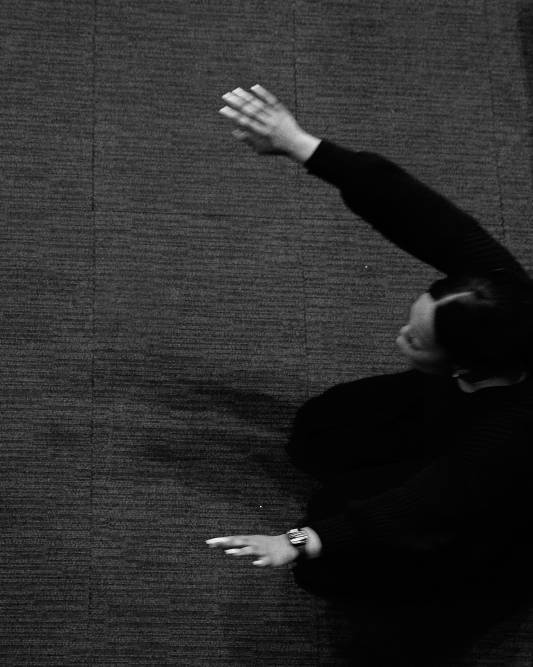 Women kneels on floor with hands outstretched in prayer